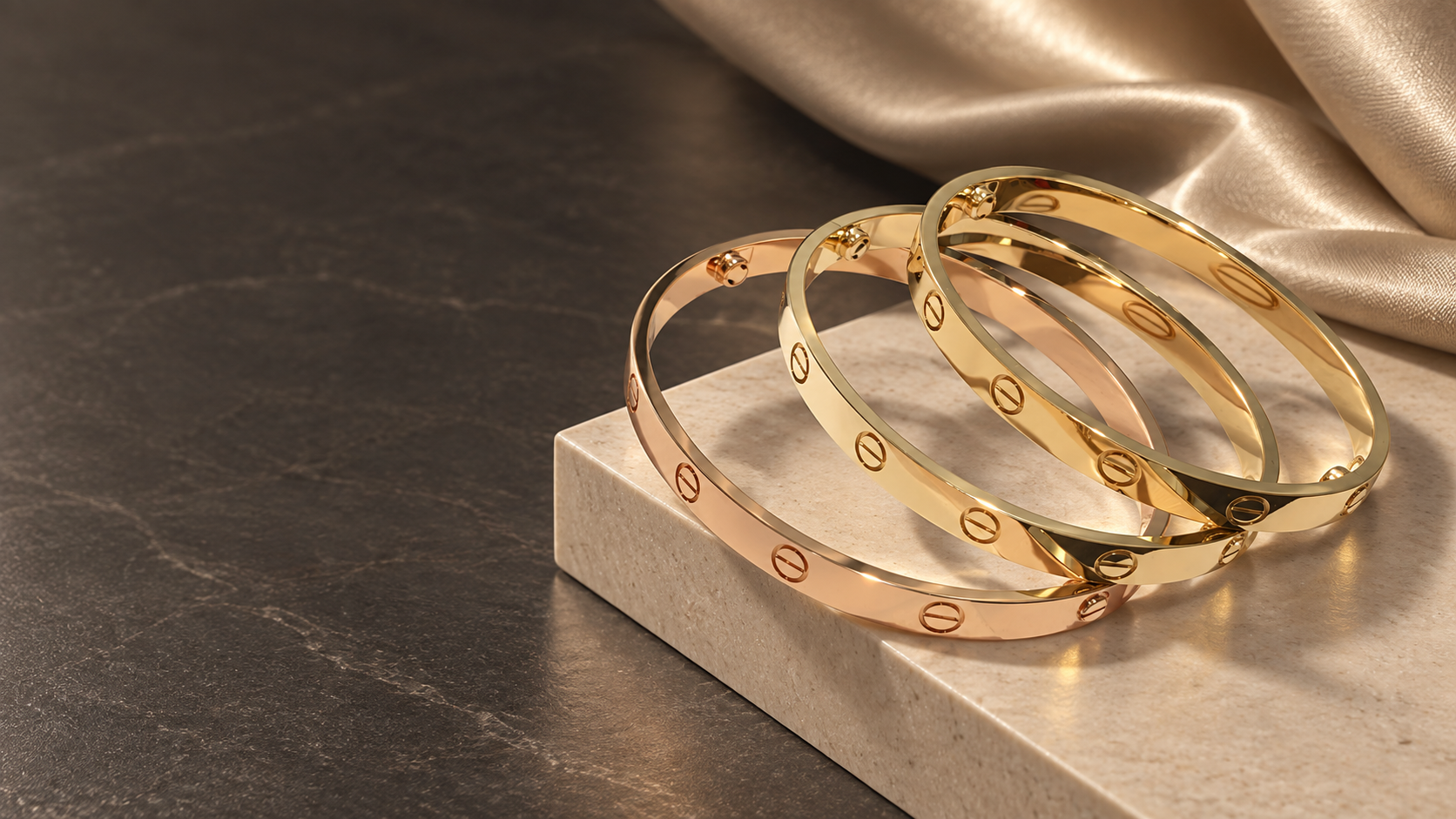 Three polished gold bangles on a luxury stone and silk setting